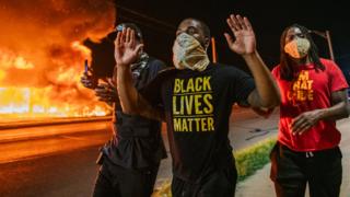 Men walk towards police officers with their hands up in Kenosha, Wisconsin, on 24 August 2020